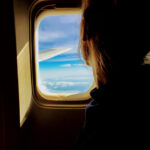 Woman looking out of plane window
