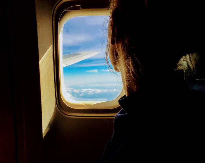 Woman looking out of plane window